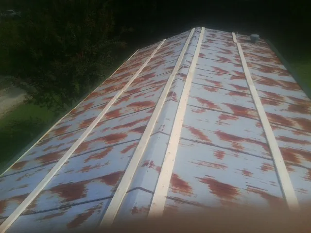 Rusted metal roof panels with new wood purlins before replacement — Storm Damage Roof Repair in Jeremiah by Roofing Brothers