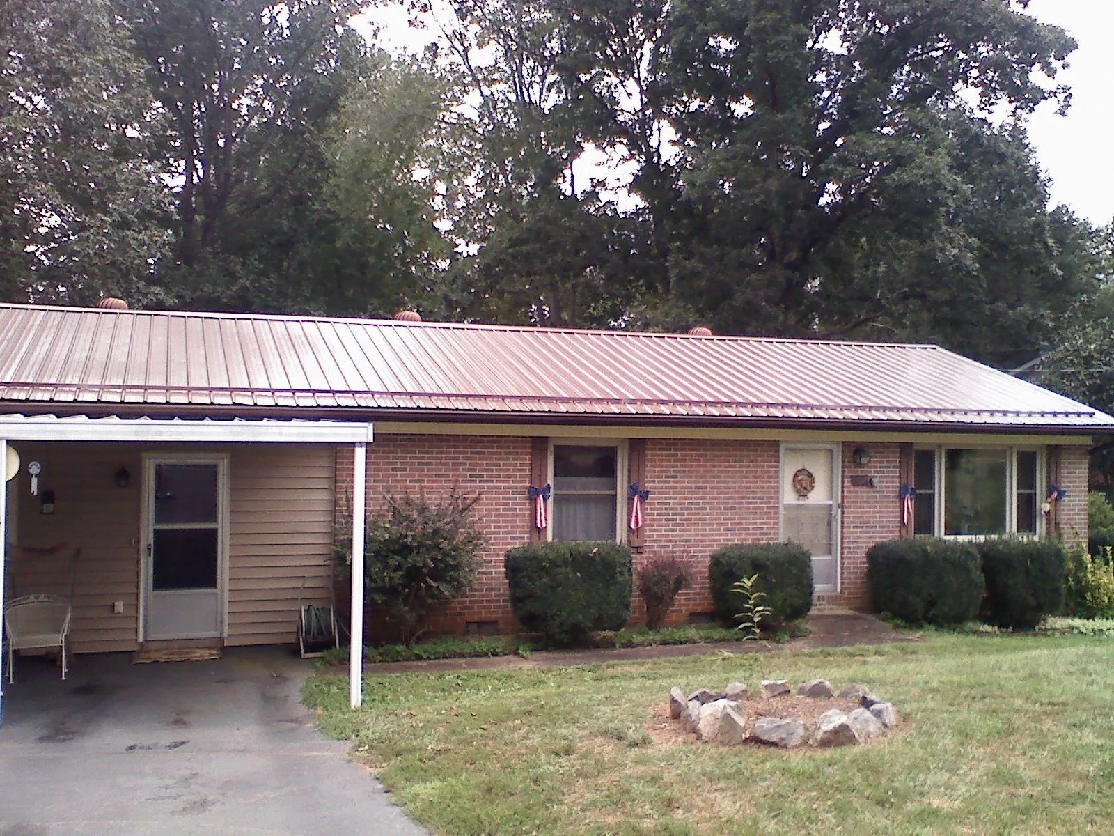 Bronze metal roof and carport on a brick ranch home — Roof Repair work by our crew in Jeremiah